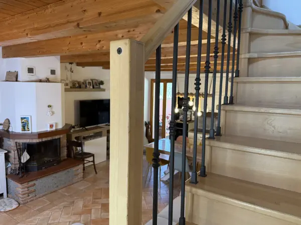 La sala da pranzo con vista sul camino e le scale per accedere al livello superiore.