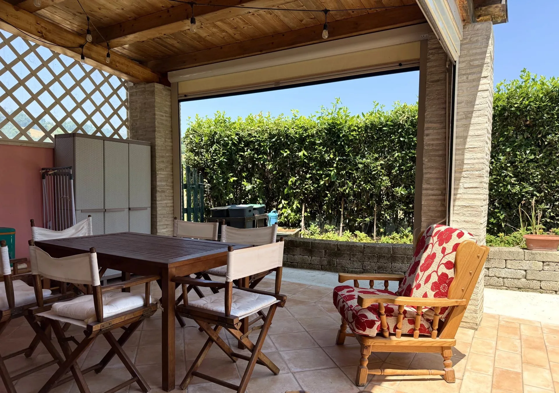 Portico in legno e mattoni con zona pranzo esterna dell'Oasi di Scapezzano