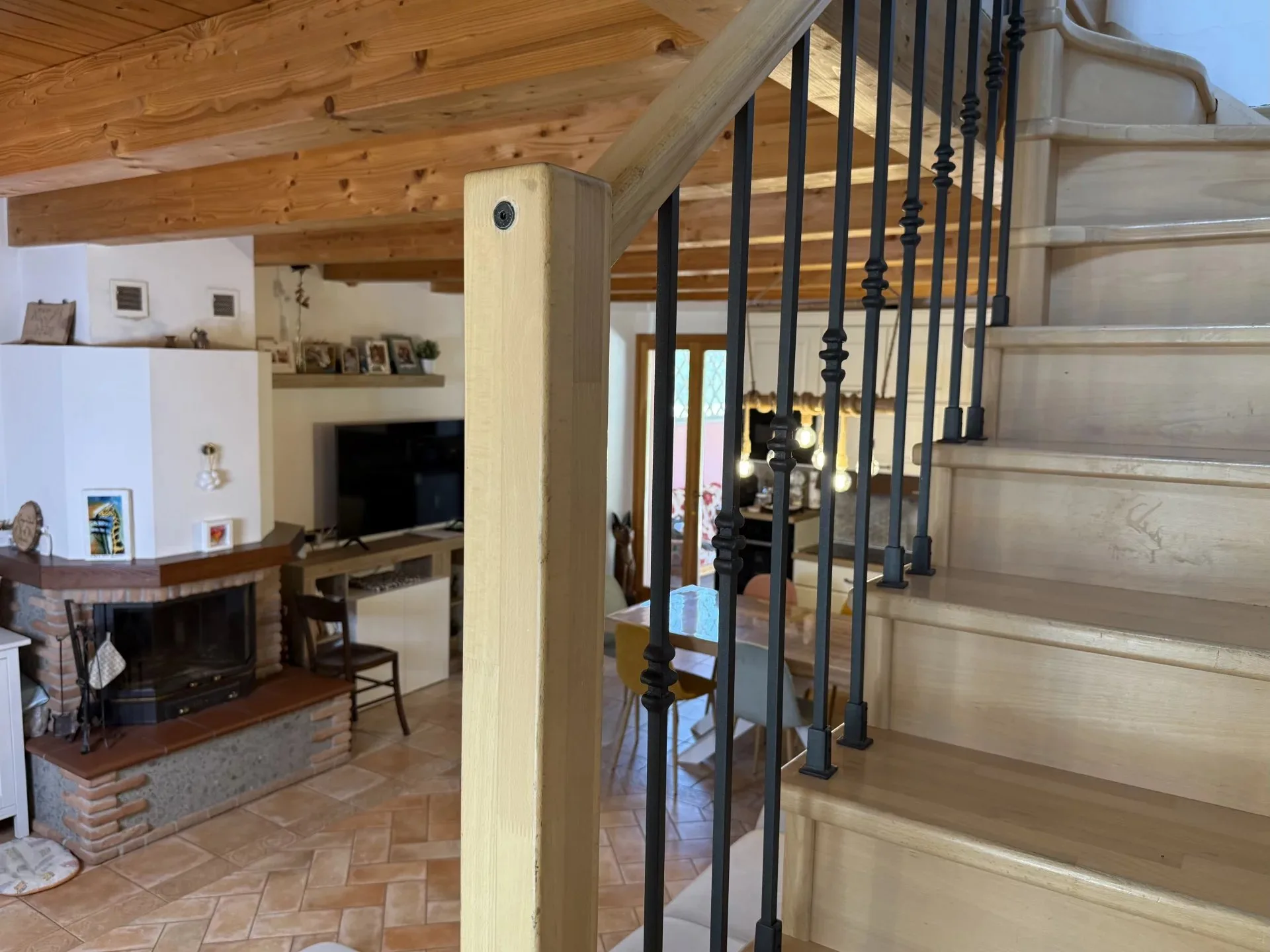 Soggiorno con camino e scala verso il piano superiore dell'Oasi di Scapezzano