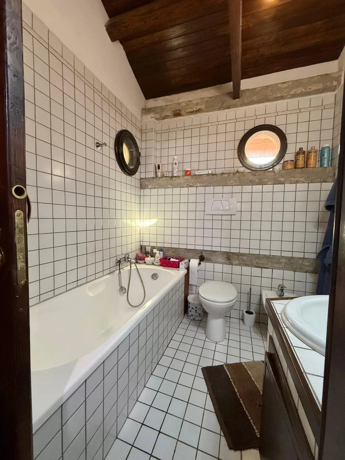 Il secondo bagno con vasca e i tipici oblò sulla parete.