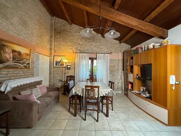 Il luminoso soggiorno con tavolo da pranzo e pratei in mattone pieno.