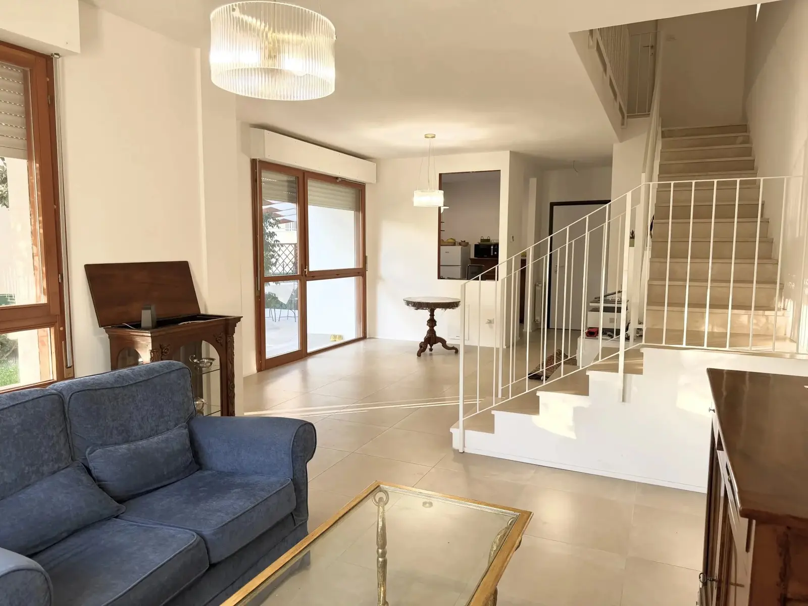 Soggiorno con divano, scala interna e ampia vetrata sul giardino, villetta indipendente a Ciarnin, Senigallia