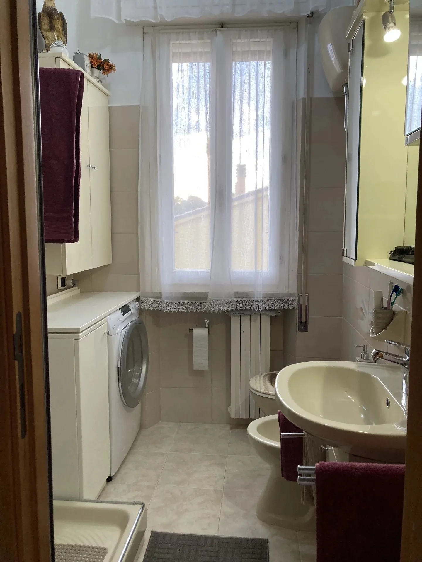 Bagno con zona lavanderia dell'appartamento a Montemarciano
