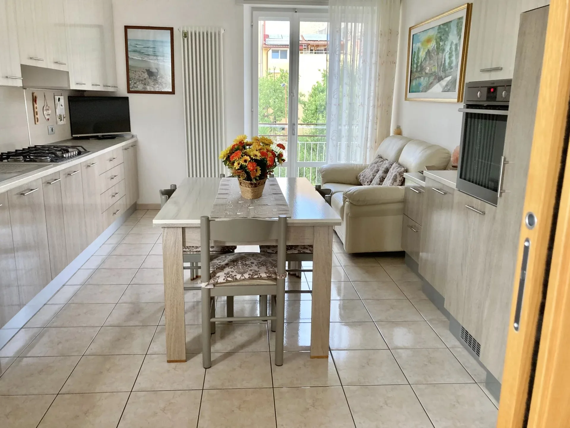 Cucina abitabile con vista sul soggiorno dell'appartamento a Montemarciano